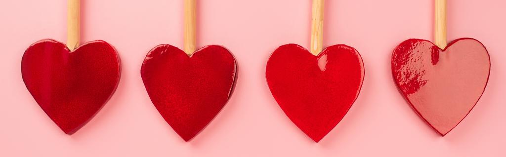 pose plate de sucettes en forme de cœur isolées sur rose, bannière - Photo, image