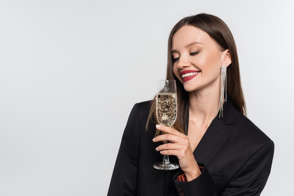 щаслива молода жінка в чорному блістері тримає келих шампанського ізольовано на сірому
 - Фото, зображення