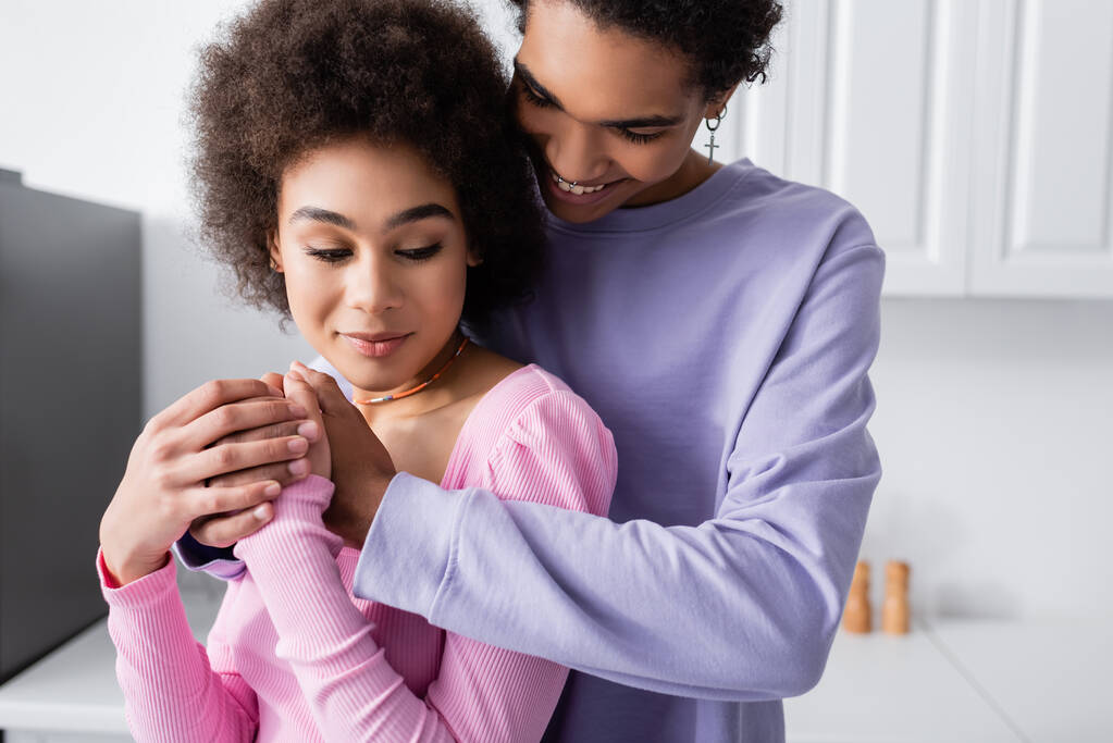 Young african american man holding hands of girlfriend in kitchen  - Photo, Image
