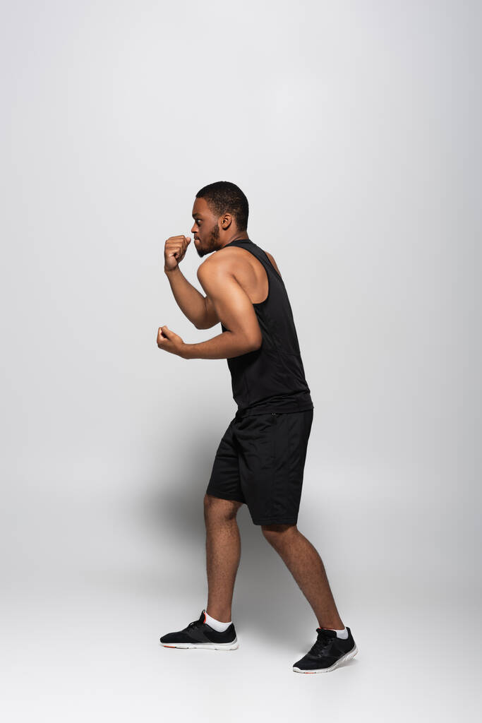アフリカ系アメリカ人のスポーツマンボクシングを灰色で見ると - 写真・画像
