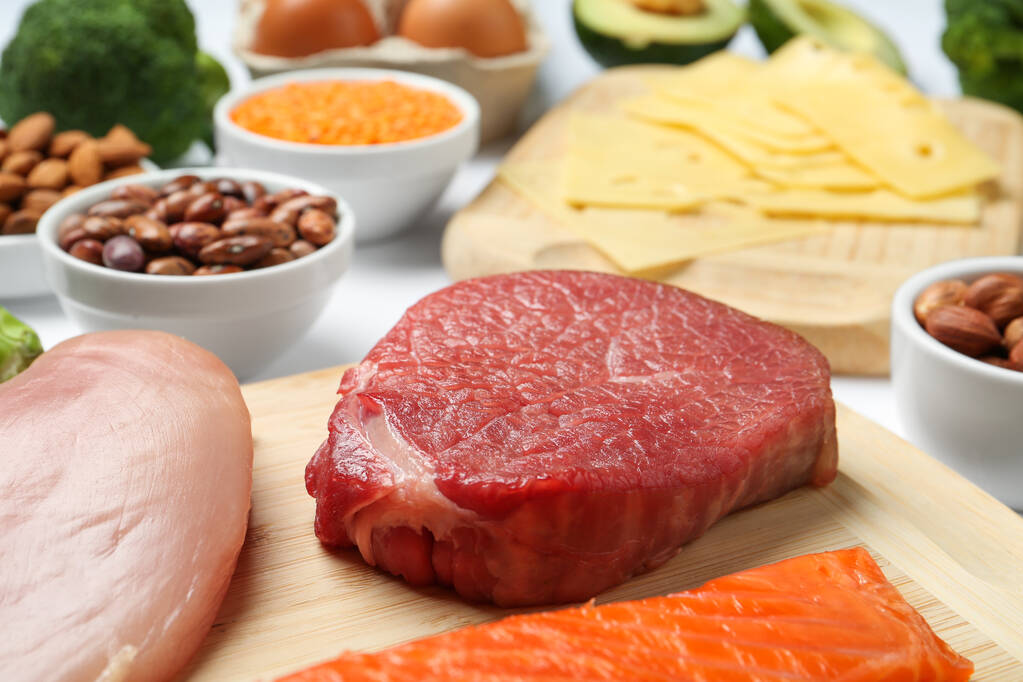Świeże mięso i inne produkty na stole, zbliżenie. Źródła niezbędnych aminokwasów - Zdjęcie, obraz