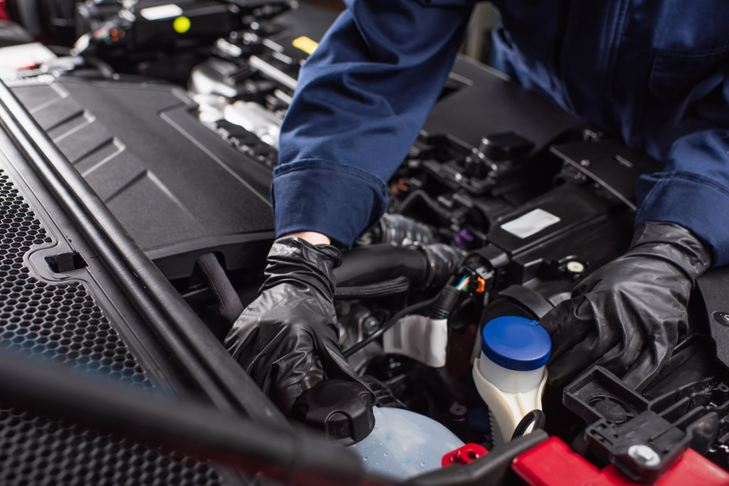 oříznutý pohled mechanika v pracovních rukavicích upevňujících motor auta  - Fotografie, Obrázek