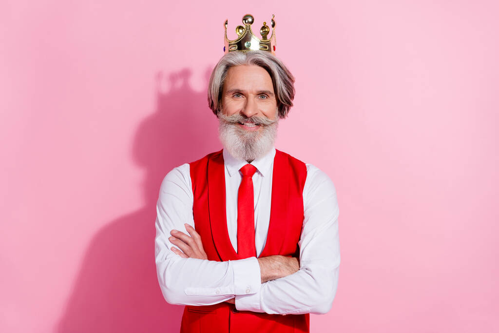 Retrato de atractivo alegre hombre de pelo gris con la corona cruzada brazos aislados sobre fondo de color pastel rosa - Foto, imagen