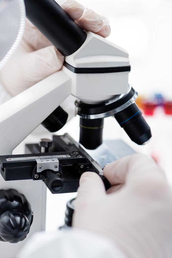 cropped view of biologist working with microscope in science laboratory, omicron variant concept - Foto, Imagem