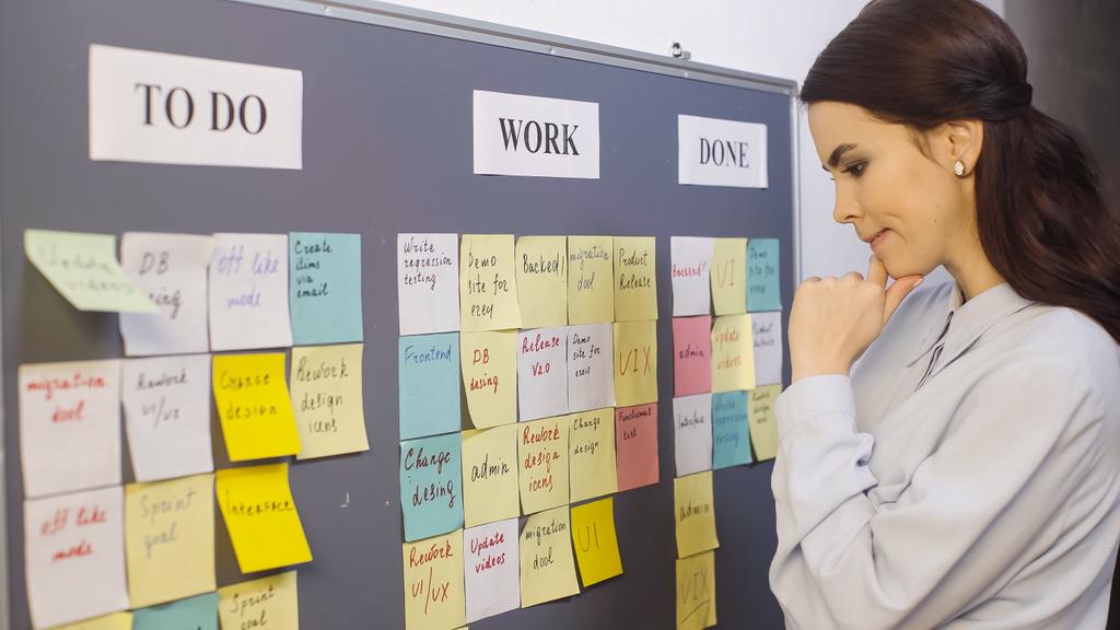 pensive businesswoman thinking near sticky notes on board - Photo, Image
