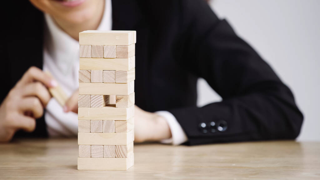 cropped view of businesswoman playing blocks wood game isolated on grey - Fotó, kép