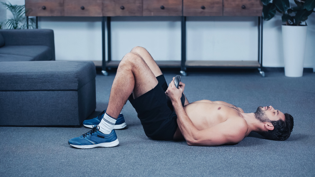izmos sportoló edz kettlebell a padlón otthon - Fotó, kép