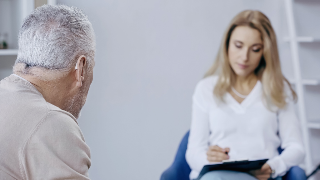 Keski-ikäinen mies lähellä hämärtynyt psykoterapeutti  - Valokuva, kuva
