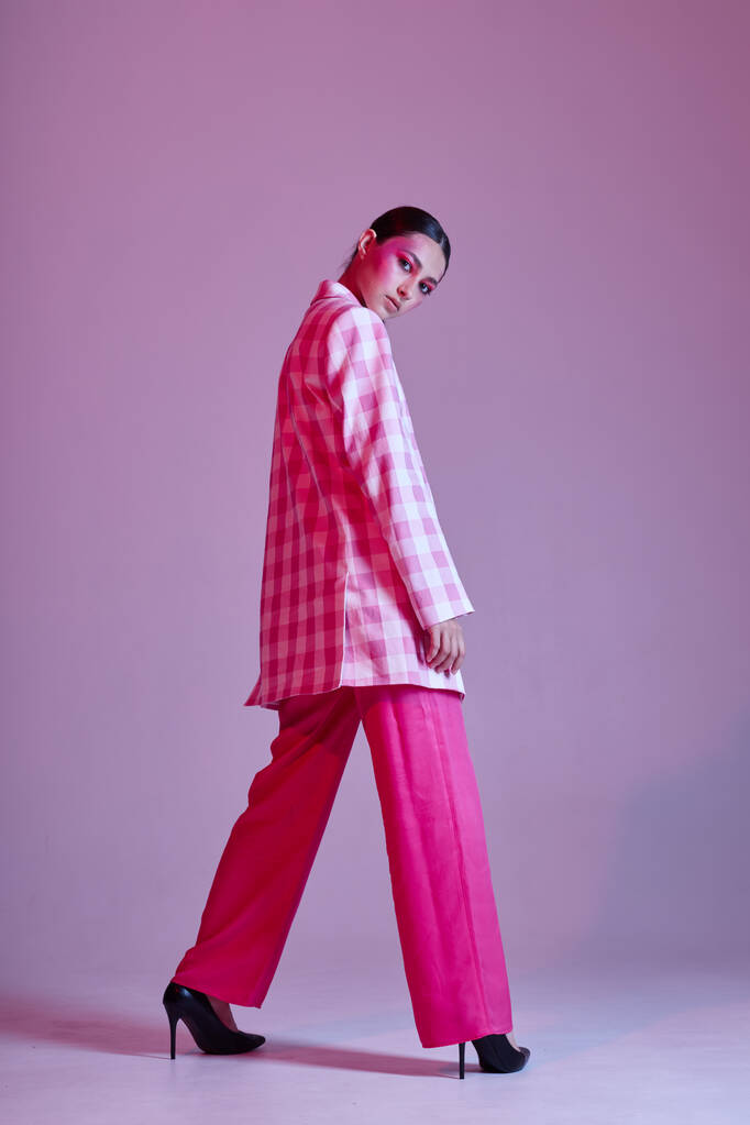 Νεαρή όμορφη γυναίκα στυλ μόδας ενδυμάτων που θέτουν μοντέρνο στυλ ροζ φόντο αναλλοίωτη - Φωτογραφία, εικόνα
