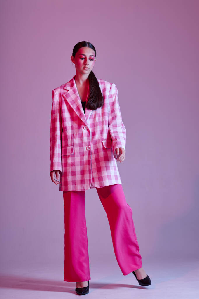 Portrait of beautiful young woman luxury clothing fashion plaid blazer pink background unaltered - Fotó, kép