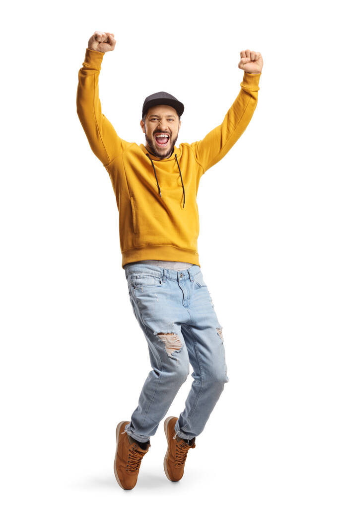 Full length portrait of a guy in a yellow sweatshirt gesturing happiness with arms up isolated on white background - Foto, Imagem