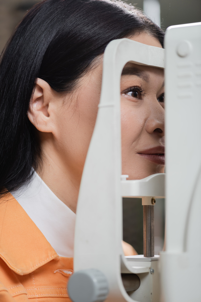 asian woman checking vision on blurred autorefractor - Foto, Bild