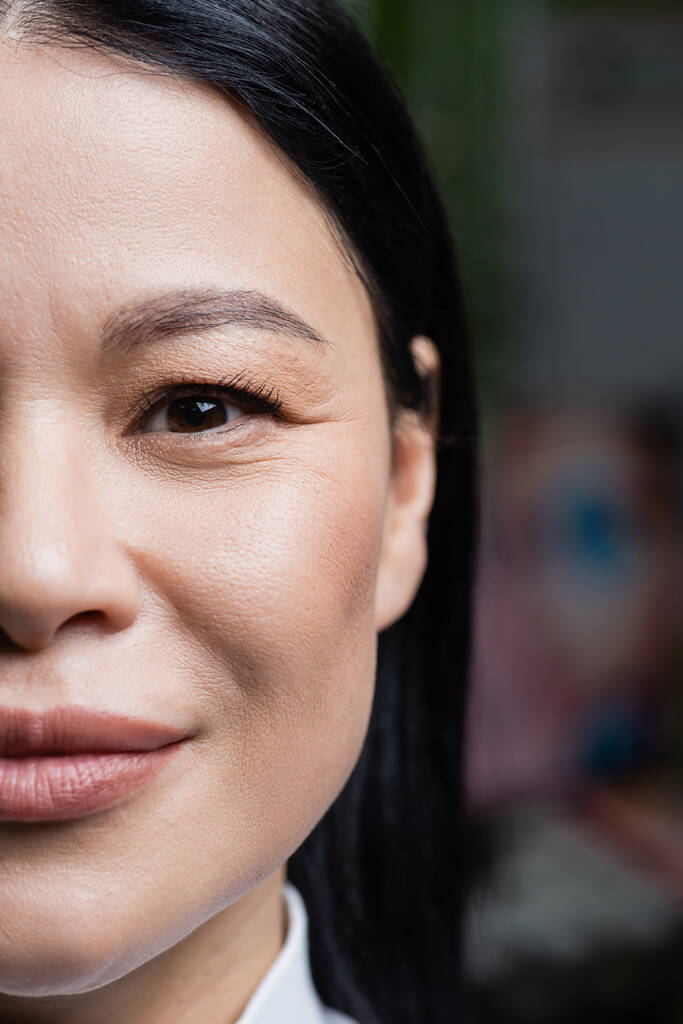partial view of smiling asian woman looking at camera, eye care concept - Photo, image