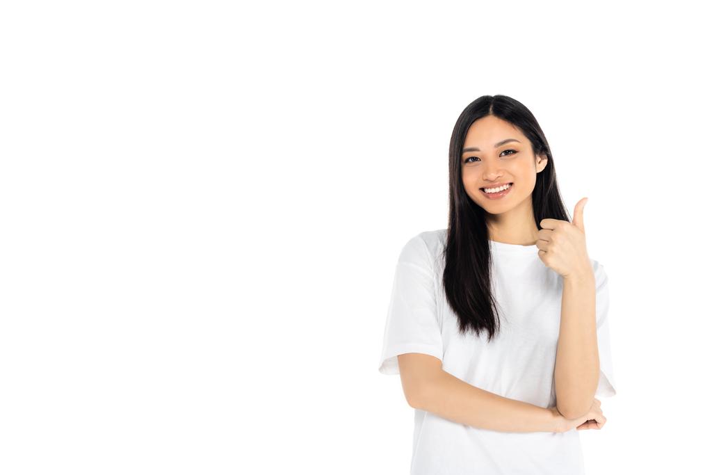 молода азіатка посміхається на камеру і показує великий палець вгору ізольовано на білому
 - Фото, зображення