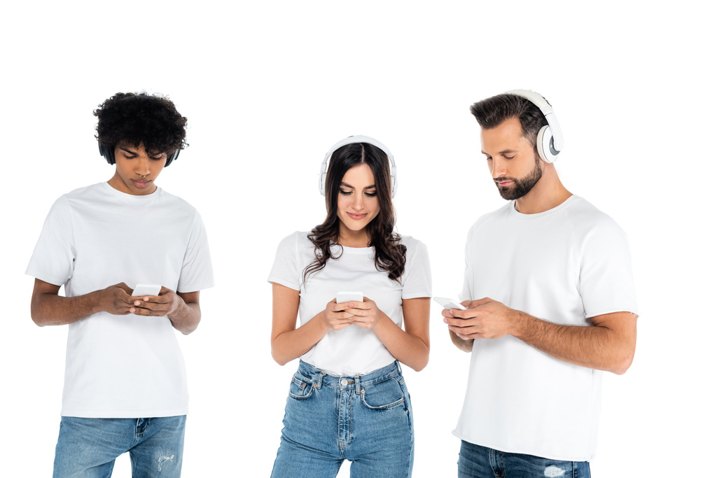wielokulturowych przyjaciół w słuchawkach za pomocą telefonów komórkowych odizolowanych w kolorze białym - Zdjęcie, obraz