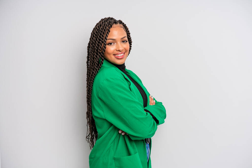 negra afro mulher sorrindo para câmera com braços cruzados e uma expressão feliz, confiante, satisfeito, vista lateral - Foto, Imagem