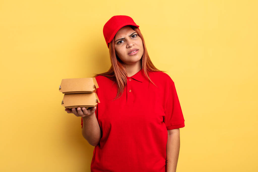 hispanic woman feeling puzzled and confused. take away deliver concept - Photo, Image