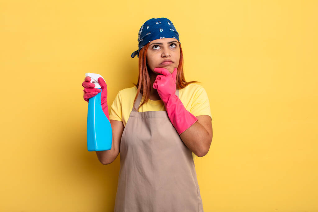 hispanic woman thinking, feeling doubtful and confused. cleaning and housekeeper concept - Photo, Image
