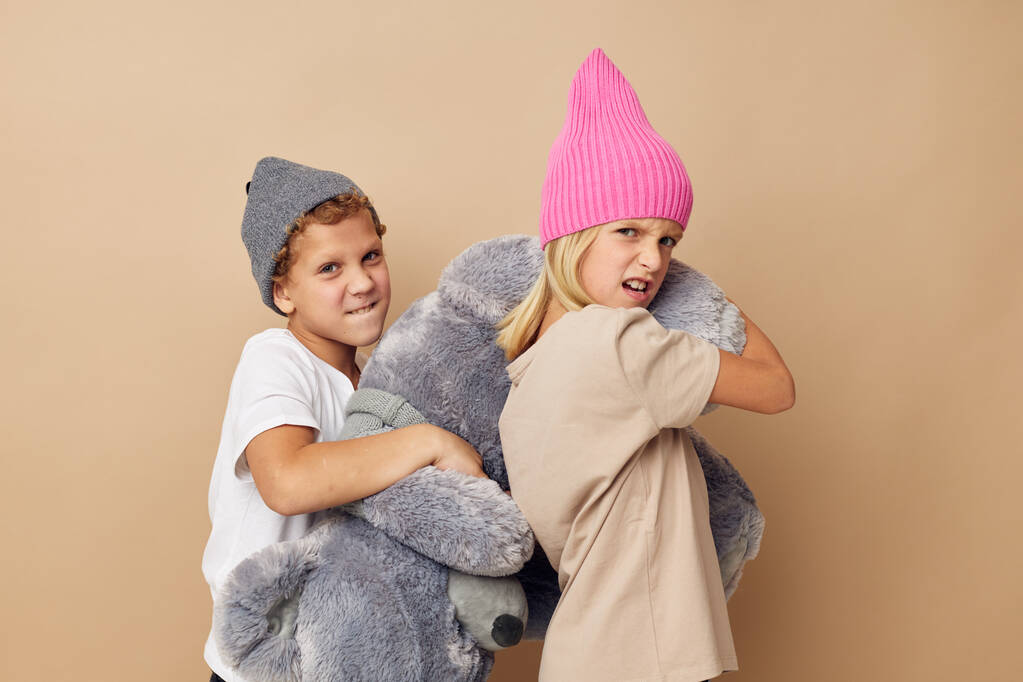 Πορτρέτο των χαριτωμένων παιδιών σε καπέλα με ένα αρκουδάκι φιλία απομονωμένη φόντο - Φωτογραφία, εικόνα