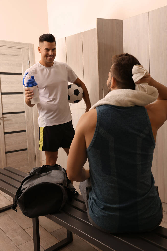 Handsome athletic men talking in locker room - Photo, Image