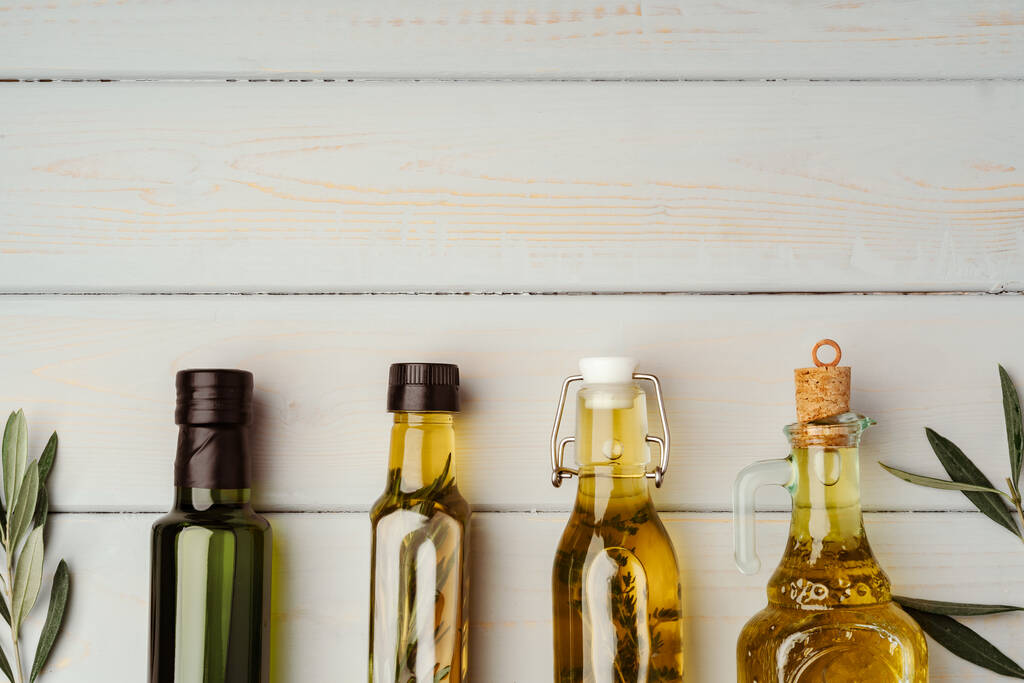 Glass bottle with olive oil on gray background - Photo, Image