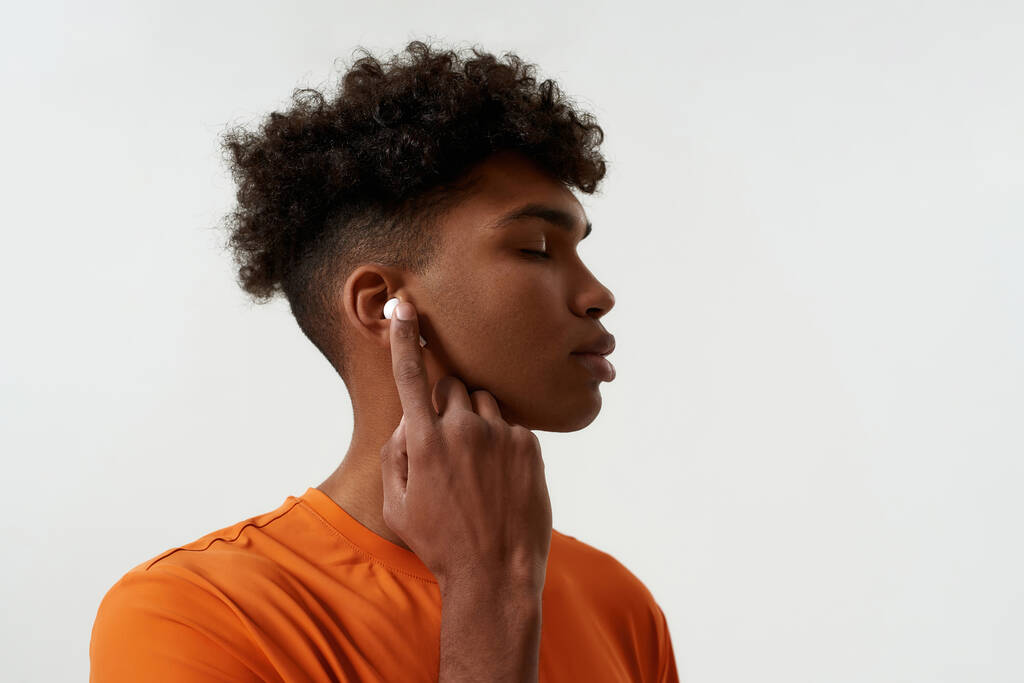 Bedachtzame zwarte man die muziek luistert in oortelefoons - Foto, afbeelding