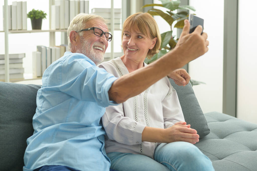 白人の幸せな高齢者は、家族や友人へのビデオ通話、自宅でのリラックス、健康的な高齢者の退職祖父母の笑顔、高齢者の祖父母技術の概念 - 写真・画像