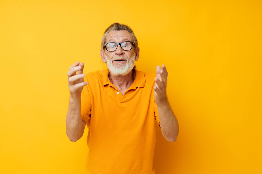 Portrait elderly man wearing glasses yellow shirt posing monochrome shot - Fotó, kép