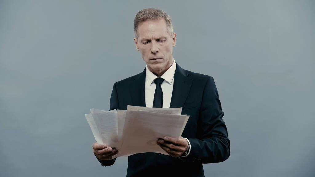 Mature manager holding documents isolated on grey  - Foto, Imagen