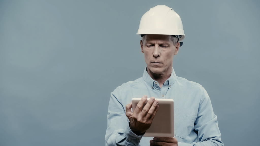 Engineer in hardhat using digital tablet isolated on grey  - Photo, Image