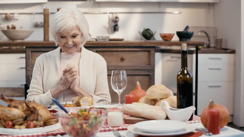 おいしい夕食の近くで笑っている驚くべき高齢女性は感謝祭のために  - 写真・画像