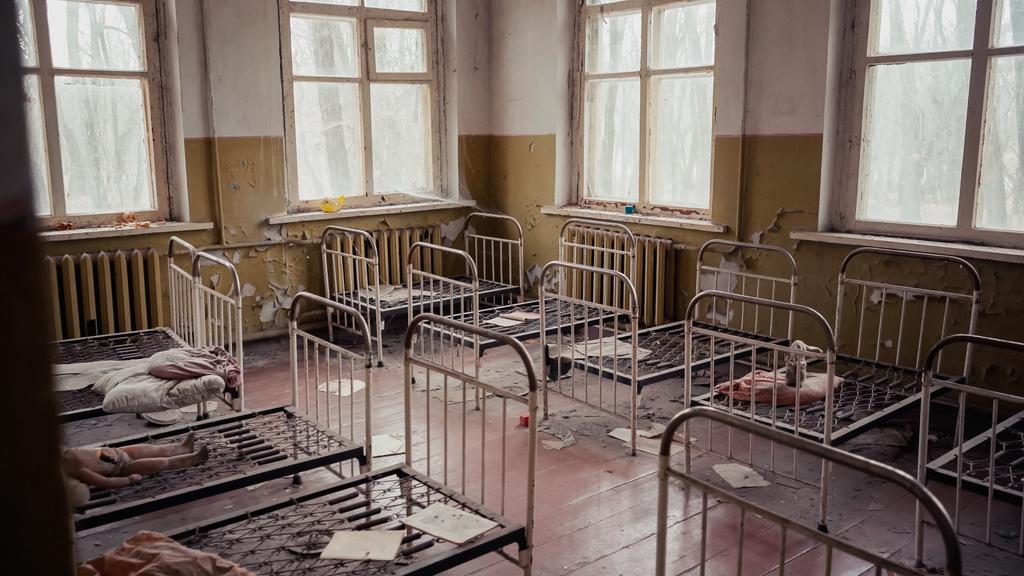 interior of abandoned kindergarten with metal beds in chernobyl exclusion zone - Foto, Imagen