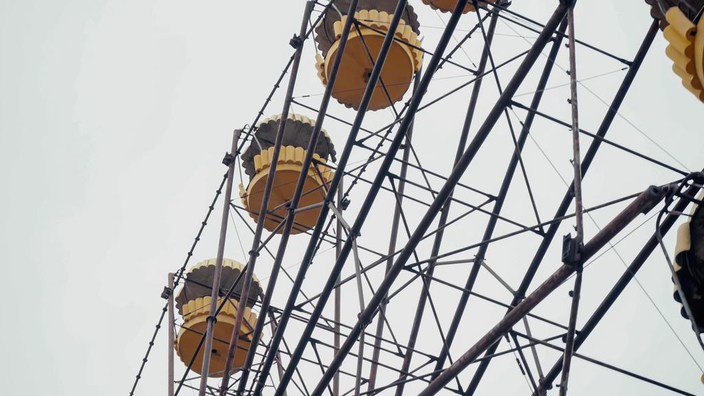 low angle view of ferris wheel in chernobyl amusement park against grey sky - Zdjęcie, obraz