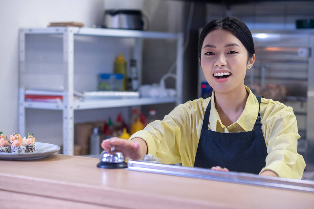 Young asian girl at the counter in the cafe - Фото, изображение