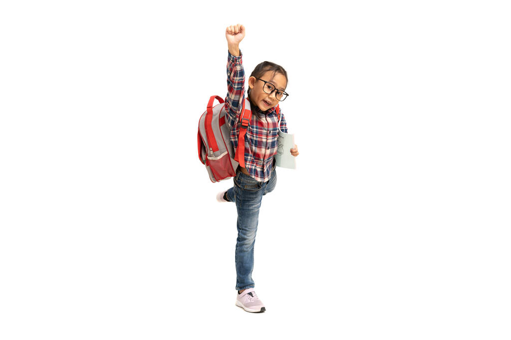 Feliz linda niña asiática en uniforme escolar sosteniendo libros, aislar sobre fondo blanco. - Foto, Imagen