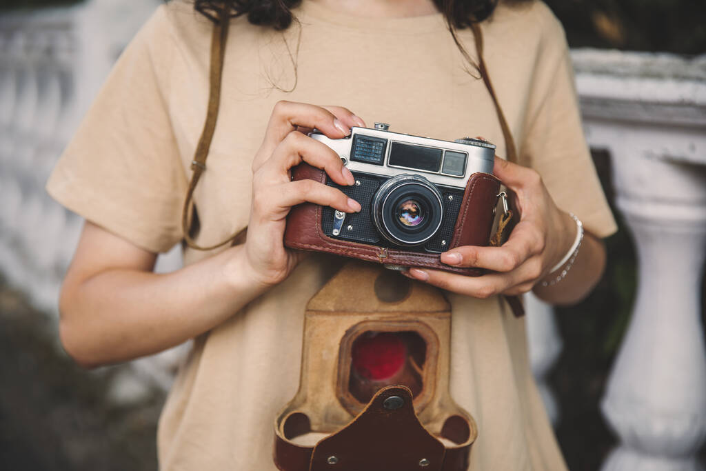 νεαρή γυναίκα κρατώντας vintage κάμερα στο stree - Φωτογραφία, εικόνα