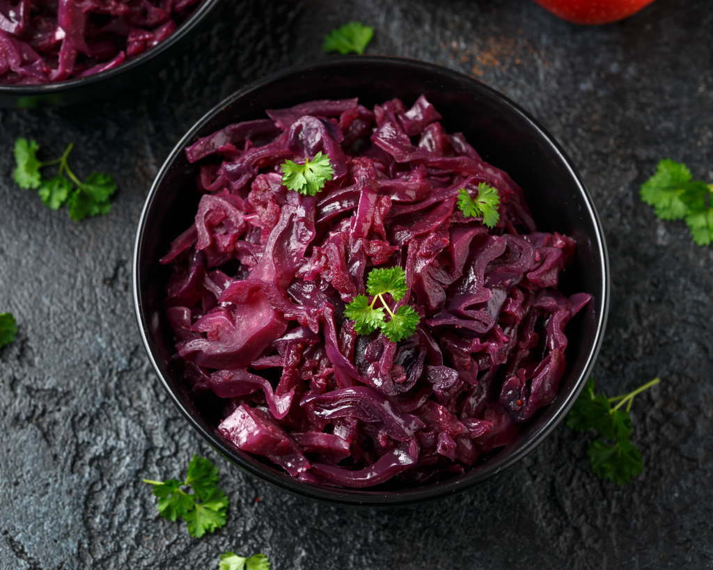 Braised Red Cabbage with apples and redcurrant in black bowl - Photo, Image