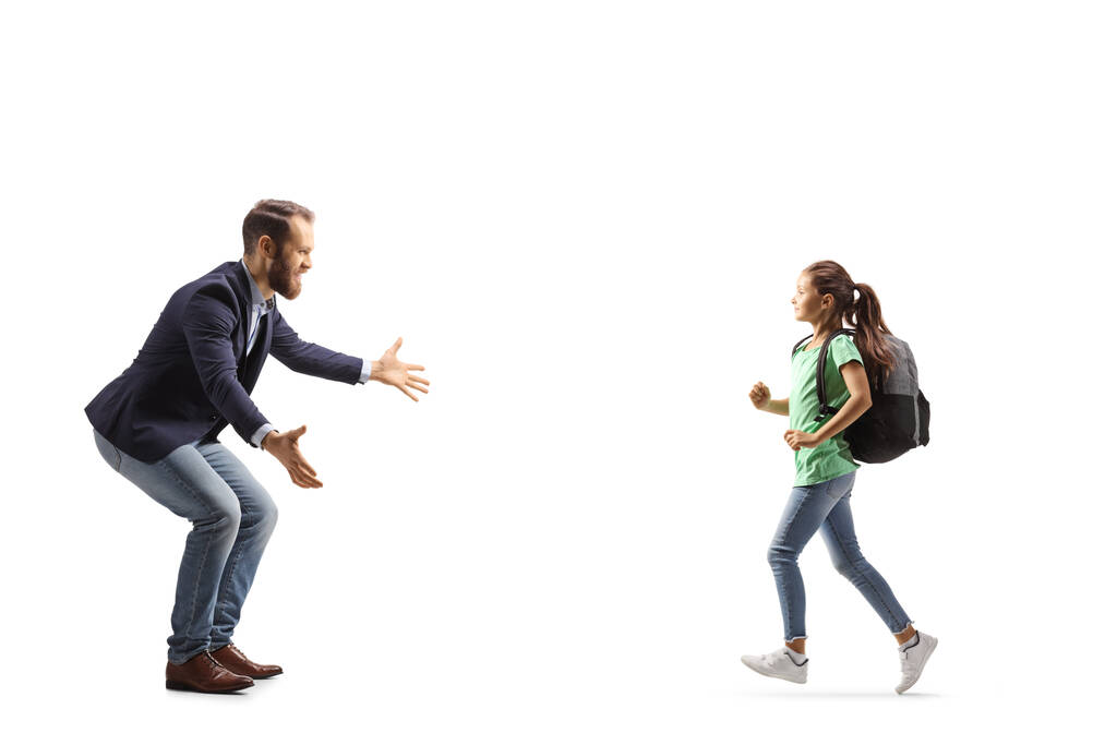 Full length profile shot of a girl with a backpack running towards a man with arms wide open isolated on white background - Fotografie, Obrázek