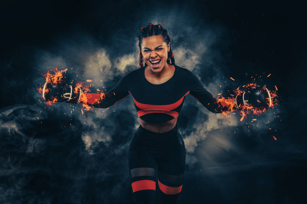 Boxing sport concept. Woman with braids on black background with smoke. Girl sportsman muay thai boxer fighting in gloves in gym. - Φωτογραφία, εικόνα