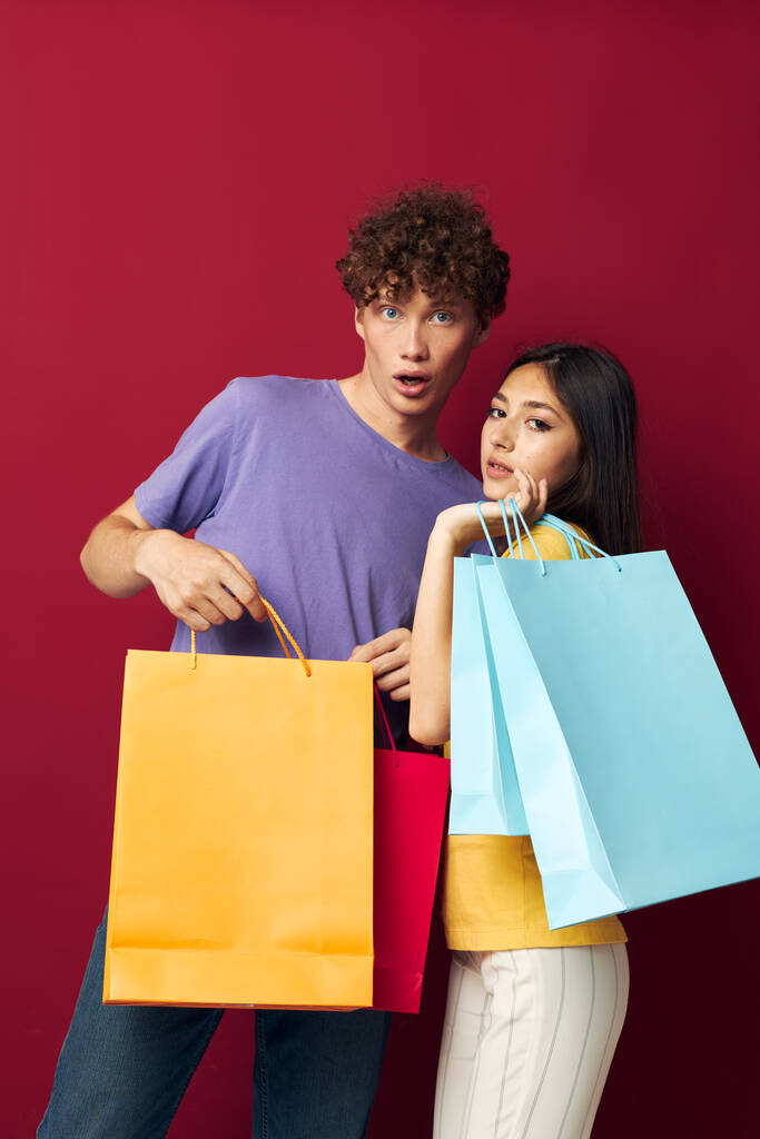 adolescents sacs colorés shopping amusant fond rouge inchangé - Photo, image