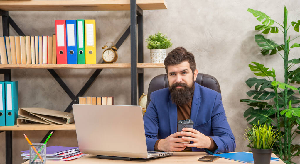 positive man freelancer use online computer communication at office holding coffee, modern life. - Zdjęcie, obraz