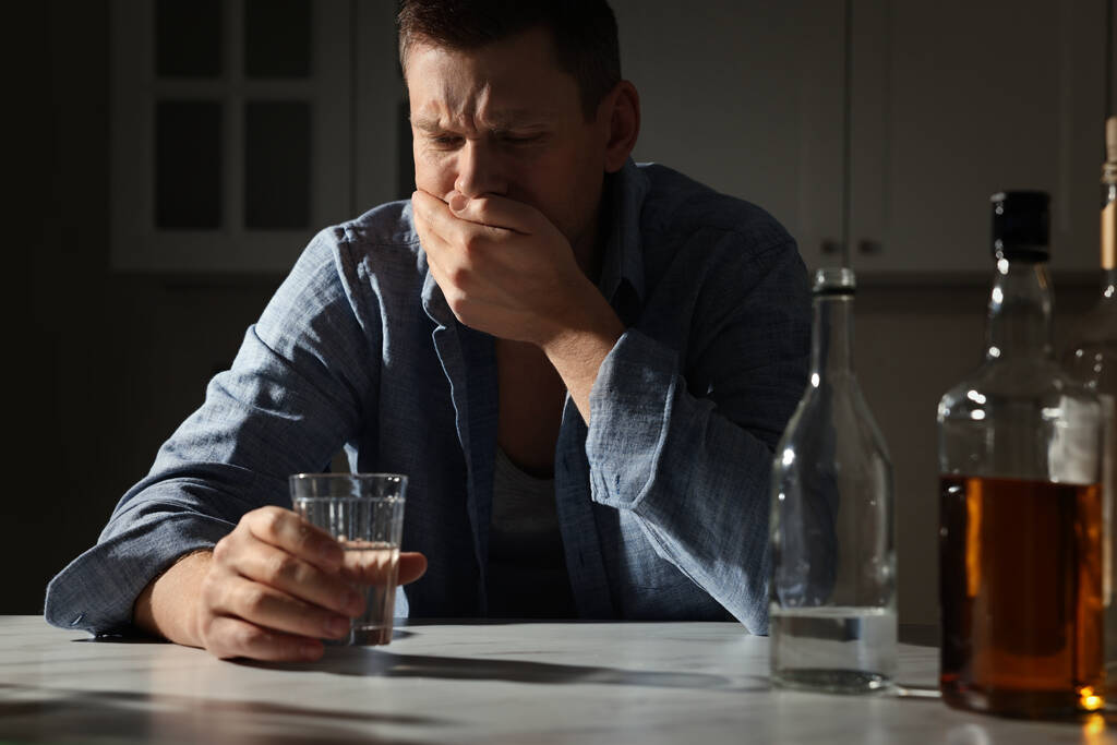 Drogfüggő részeg férfi alkoholos itallal a konyhában - Fotó, kép