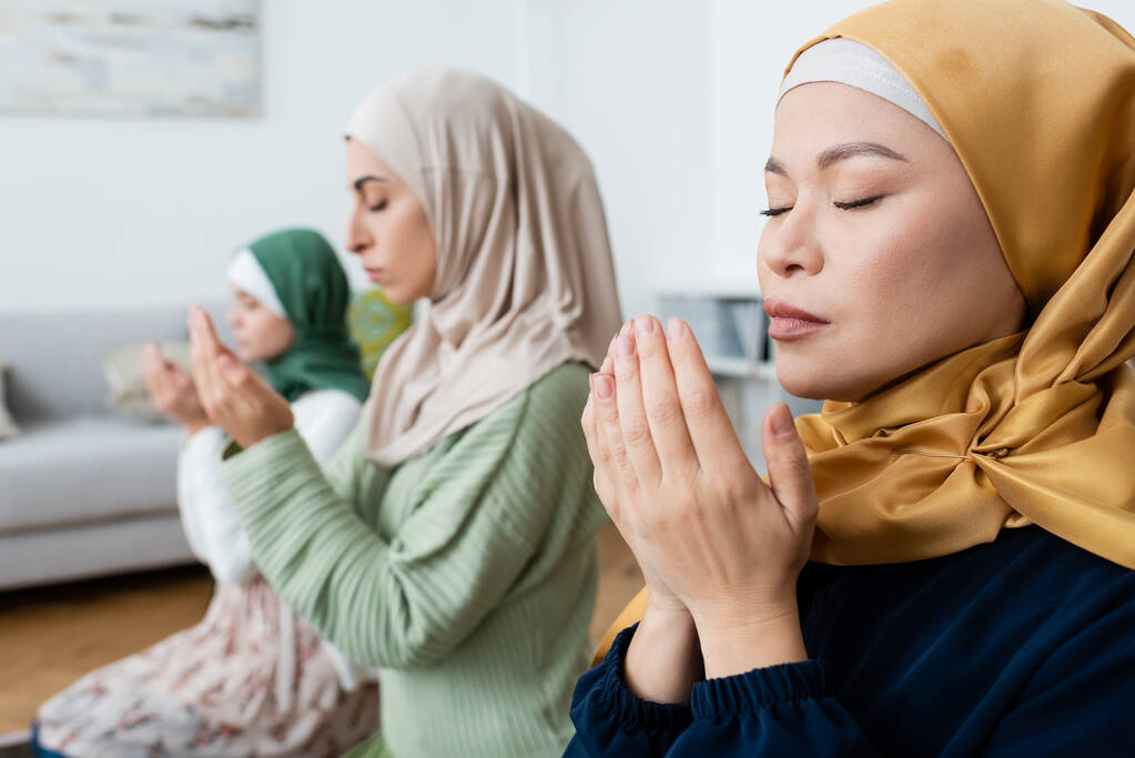 Ázsiai nő imádkozik közelében elmosódott muszlim lánya és unokája otthon - Fotó, kép