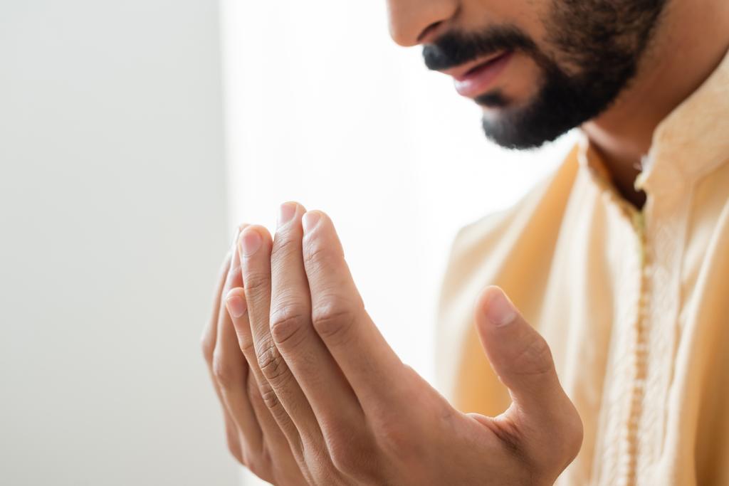 Vágott kilátás a kezét elmosódott arab férfi imádkozik otthon  - Fotó, kép