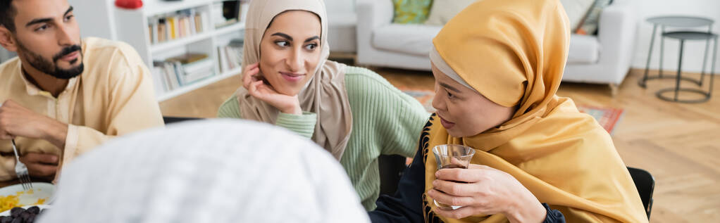 asian woman holding glass of tea during family dinner with muslim family, banner - Photo, Image