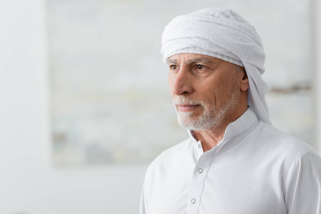 uomo di mezza età mislim in turbante bianco guardando lontano a casa - Foto, immagini