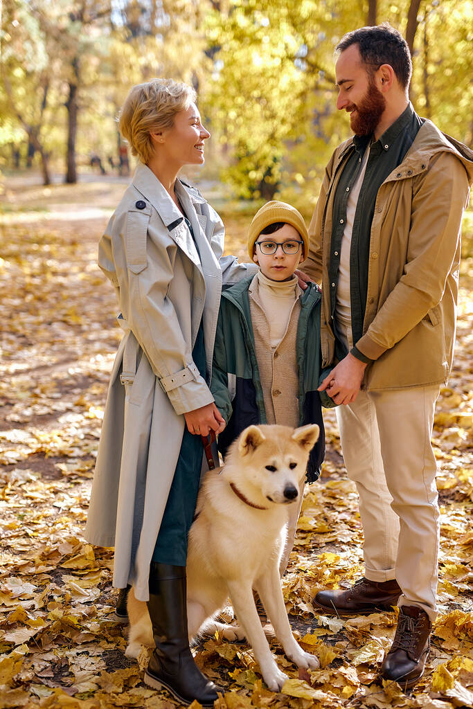 Usmívající se rodina tráví podzimní víkendy venku, procházejí se spolu v lese - Fotografie, Obrázek