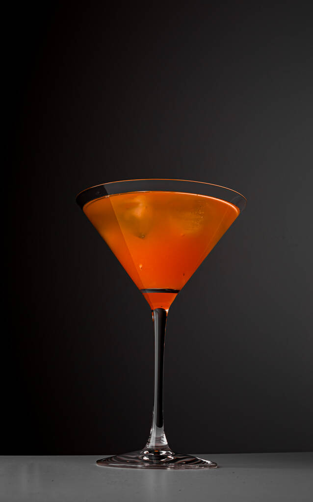 Фруктовий здоровий коктейль з манго, спіраль апельсинової шкірки та лід на темно-чорному тлі
. - Фото, зображення