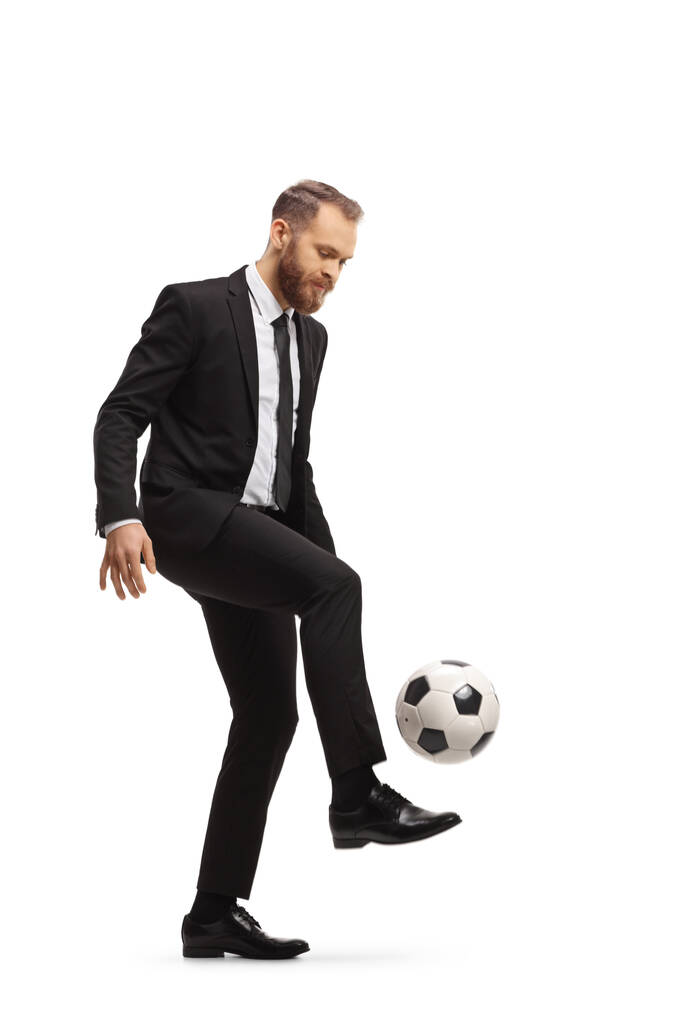 Full length shot of a businessman kicking a football isolated on white background - Zdjęcie, obraz