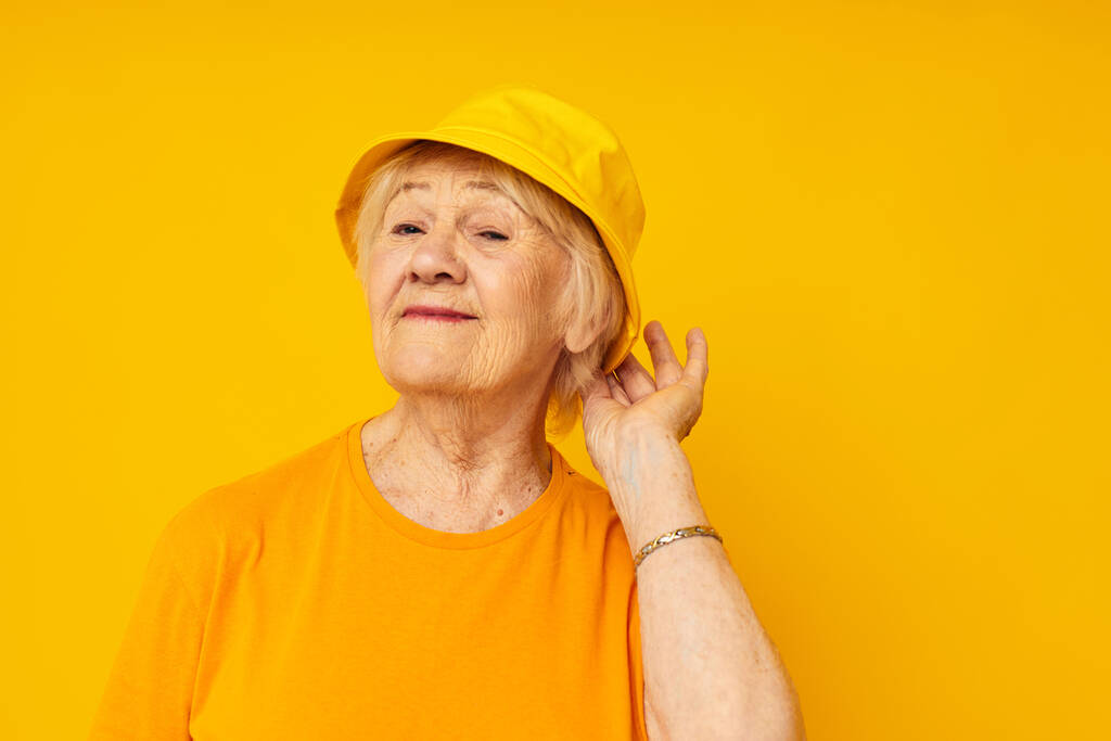 uśmiechnięta starsza kobieta szczęśliwy styl życia w żółtym nakryciu głowy zbliżenie emocji - Zdjęcie, obraz